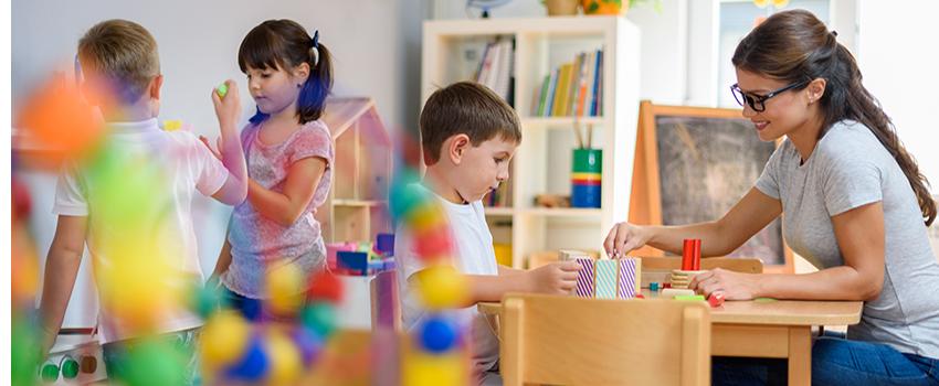 Teacher working with kids with building blocks