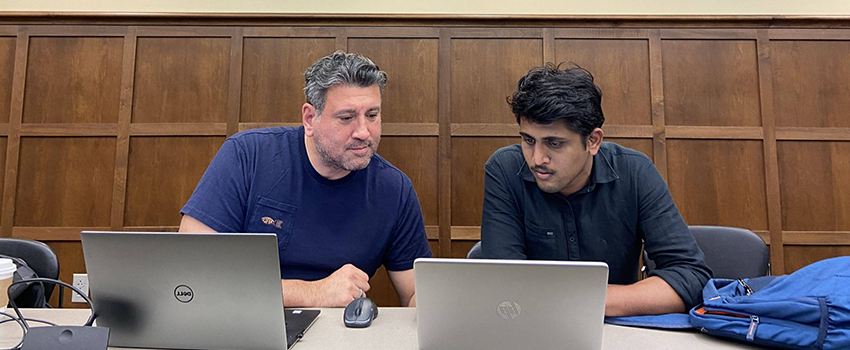 Two students looking into a computer screen in a classroom 